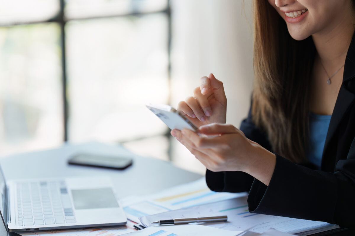 暗号資産取引アプリを使って相場を確認する女性投資家のイメージ。投資や資産管理をスマホで行う様子